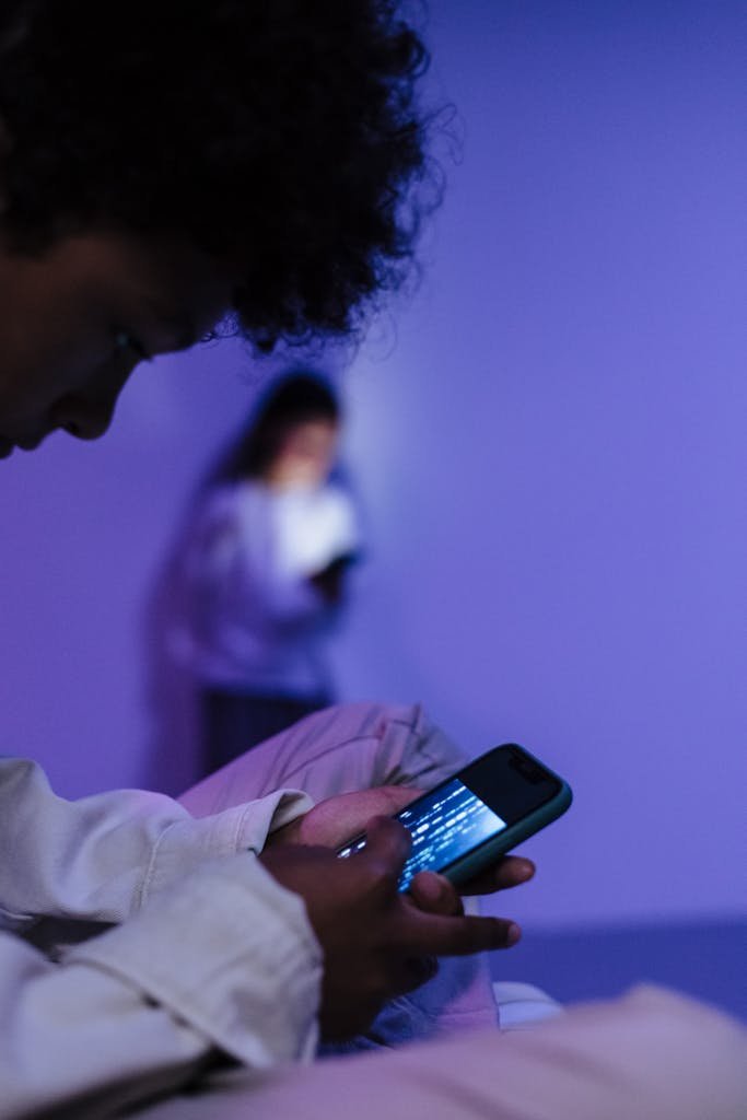 Focused teens using smartphones indoors, creating a modern tech atmosphere.