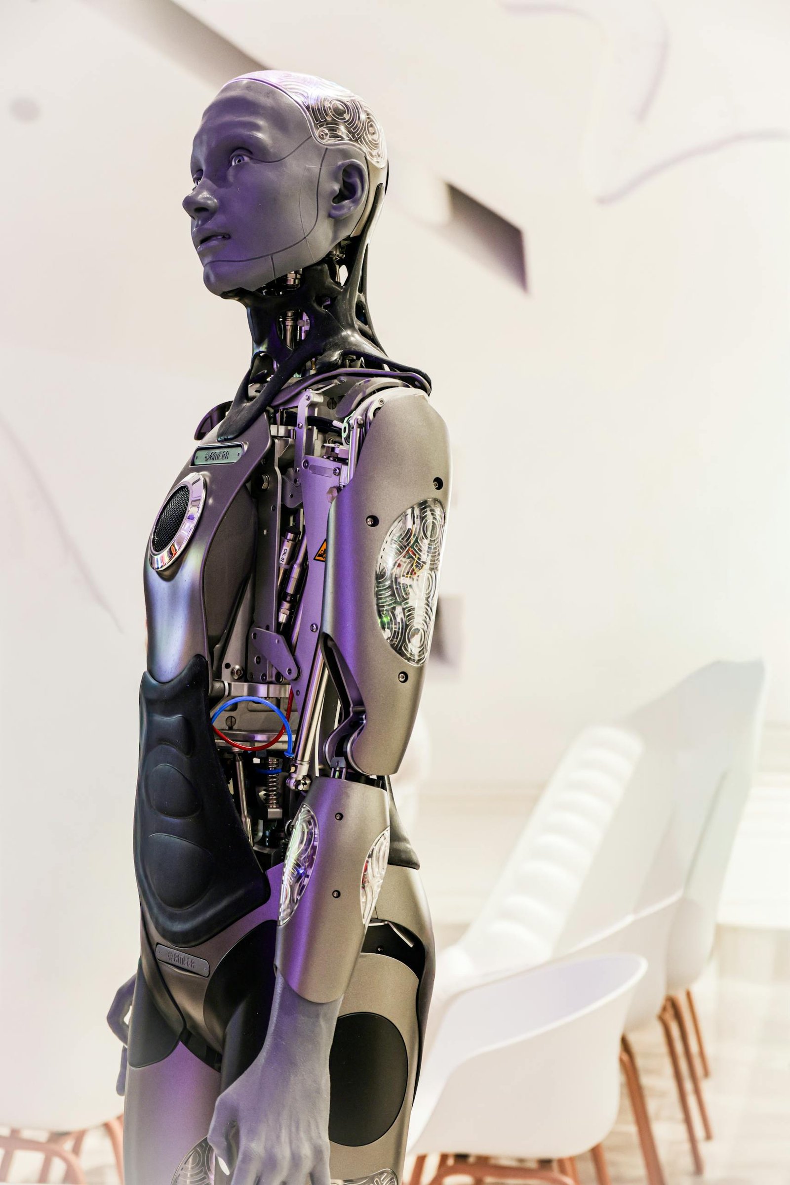 Sleek humanoid robot displayed in a contemporary conference setting, showcasing advanced technology.